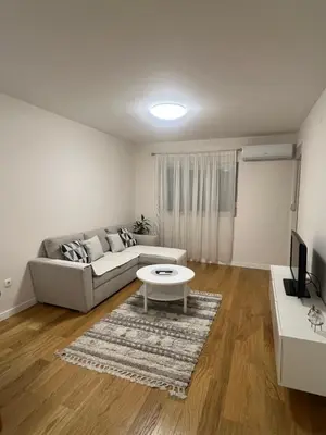 a living room with a couch and a table at Cozy 1bd apartment Central point-GARAGE available 5e per day in Podgorica