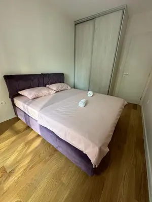 a bedroom with a bed with two pillows on it at Cozy 1bd apartment Central point-GARAGE available 5e per day in Podgorica