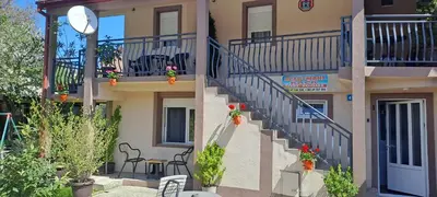 a building with stairs leading to a balcony with plants at Studio Kaća 2 in Cetinje