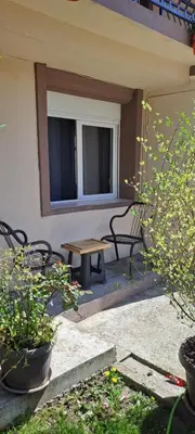 a patio with benches and a table and a window at Studio Kaća 2 in Cetinje