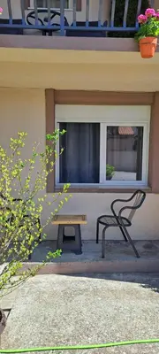 a bench sitting in front of a window next to a table at Studio Kaća 2 in Cetinje