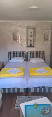 two beds in a room with yellow blankets on them at Studio Kaća 2 in Cetinje