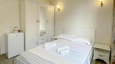 a bedroom with a white bed with two pillows on it at Guest House Bonaca in Ulcinj