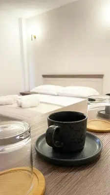a coffee cup sitting on a table next to a bed at Guest House Bonaca in Ulcinj