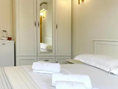 a white bedroom with a mirror and a bed at Guest House Bonaca in Ulcinj