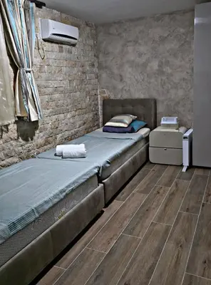 a bedroom with a bed and a brick wall at APARTMAN NIKA BUDVA-PRZNO in Budva