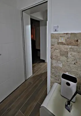 a room with a chair and a stone wall at APARTMAN NIKA BUDVA-PRZNO in Budva