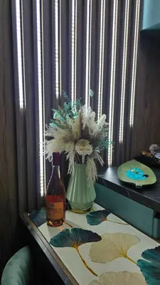 a bottle of wine and a vase with flowers on a table at APARTMAN NIKA BUDVA-PRZNO in Budva