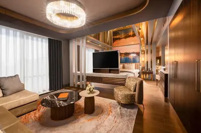 a living room with a couch and a television at Merit Starlit Hotel & Residences in Budva