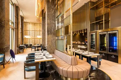 a restaurant with tables and chairs and a bar at Merit Starlit Hotel & Residences in Budva