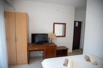 a bedroom with a desk with a tv and a bed at Villa Elezi in Ulcinj