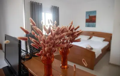 two vases with flowers on a table in a bedroom at Villa Elezi in Ulcinj