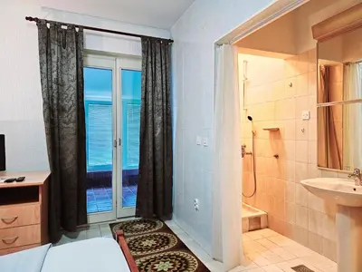 a bathroom with a bed and a shower and a window at Bravo Plus in Budva