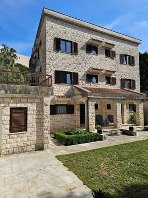 a large stone building with windows and a patio at Bravo Plus in Budva