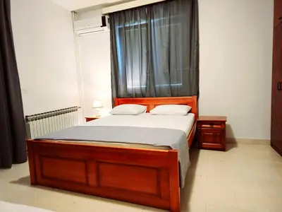a bedroom with a large wooden bed with a window at Bravo Plus in Budva