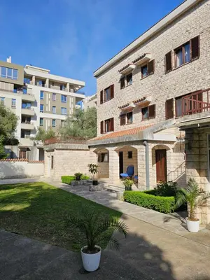 a large brick building with a yard in front of it at Bravo Plus in Budva