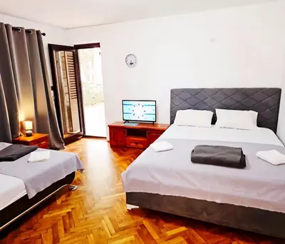 a bedroom with two beds and a flat screen tv at Bravo Plus in Budva