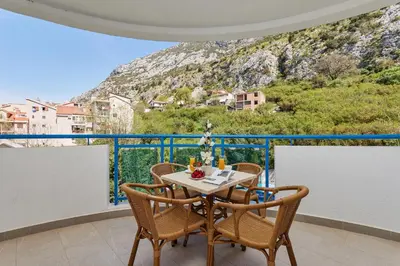 a table and chairs on a balcony with a view at Apartment Hill with Free Garage Spot in Kotor