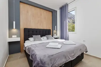 a bedroom with a large bed with two towels on it at Apartment Hill with Free Garage Spot in Kotor