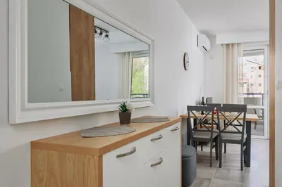 a kitchen with a mirror and a table with chairs at Apartment Hill with Free Garage Spot in Kotor