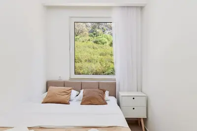 a bedroom with a bed and a window at Apartment Hill with Free Garage Spot in Kotor