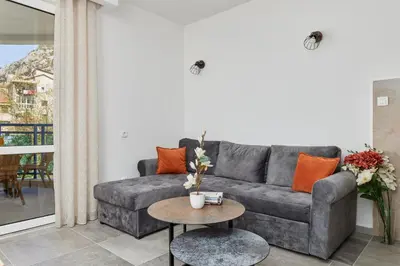 a living room with a gray couch and a table at Apartment Hill with Free Garage Spot in Kotor