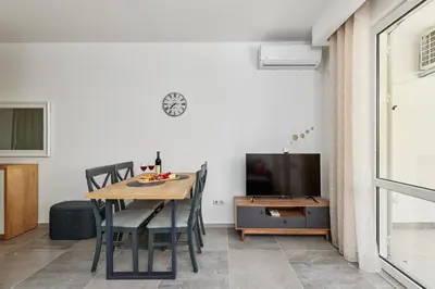 a dining room with a table and a tv at Apartment Hill with Free Garage Spot in Kotor