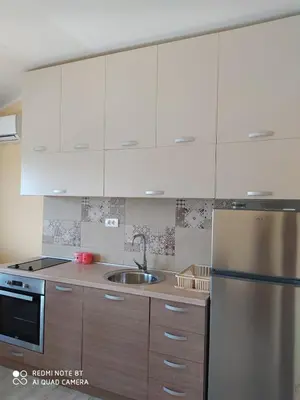 a kitchen with white cabinets and a stainless steel refrigerator at Rada in Kavač