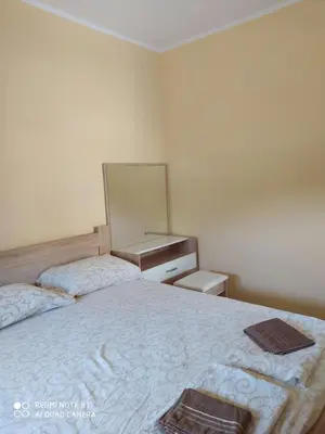 a bedroom with two beds and a mirror on the wall at Rada in Kavač