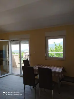 a dining room with a table and chairs and a window at Rada in Kavač