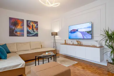 a living room with a couch and a tv on a wall at Apartment UR in Bar