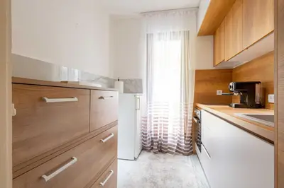 a kitchen with wooden cabinets and a white refrigerator at Apartment UR in Bar