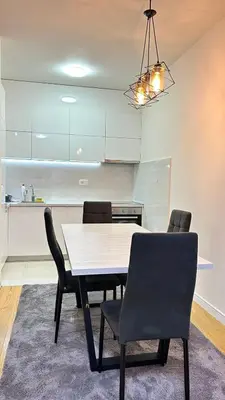 a dining room table and chairs in a kitchen at Comfort Central Point apartment in Podgorica