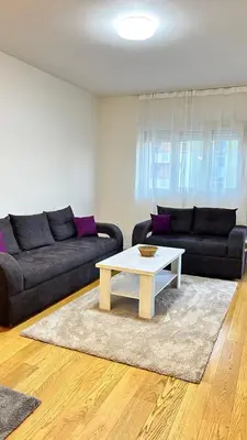a living room with a couch and a coffee table at Comfort Central Point apartment in Podgorica