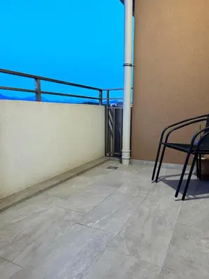 a balcony with a table and chairs on a building at Comfort Central Point apartment in Podgorica