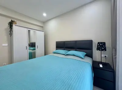 a bedroom with a blue bed and a mirror at Danver Apartment in Bar