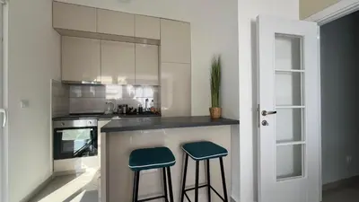 a kitchen with two stools sitting at a counter at Danver Apartment in Bar