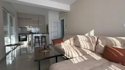 a living room with a couch and a kitchen at Danver Apartment in Bar