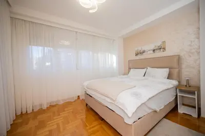 a bedroom with a large bed and a window at Apartman Klara Podgorica in Podgorica