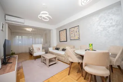 a living room with a couch and a table and chairs at Apartman Klara Podgorica in Podgorica