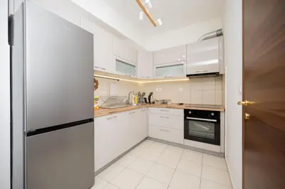 a kitchen with white cabinets and a refrigerator at Apartman Klara Podgorica in Podgorica
