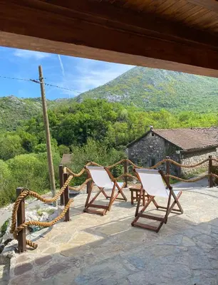 two chairs on a patio with a view of a mountain at Skadar Lake House Nature Nest in Virpazar