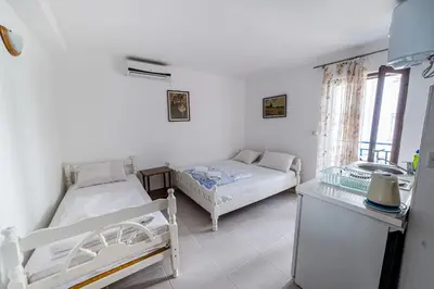 a bedroom with two beds and a window at Apartments Vila Nikolić Rafailovići in Rafailovici