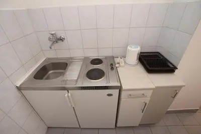 a small kitchen with a sink and a sink at Apartments Vila Nikolić Rafailovići in Rafailovici