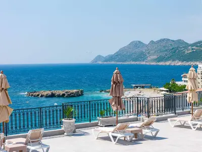 a view of the ocean from a resort with chairs and umbrellas at Vienna Luxury Apartments in Dobra Voda