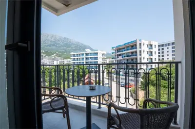a balcony with a table and chairs and a view of a city at Vienna Luxury Apartments in Dobra Voda