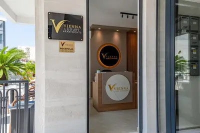 a glass door of a building with a sign on it at Vienna Luxury Apartments in Dobra Voda