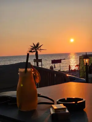 a drink on a table with a view of the ocean at Vienna Luxury Apartments in Dobra Voda