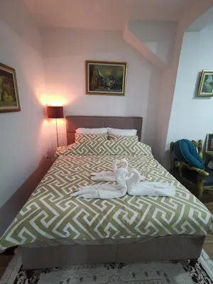 a bedroom with a bed with two dolls laying on it at In Apartments AirPort in Mitrovići
