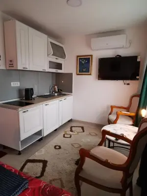 a kitchen with white cabinets and a sink at In Apartments AirPort in Mitrovići